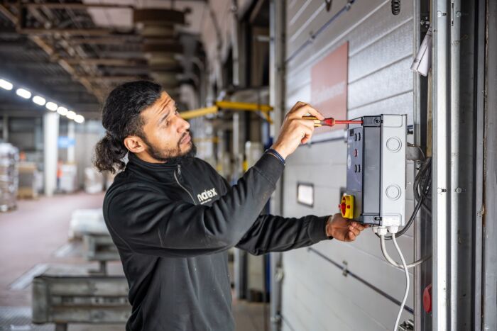 Monteur van Matex die onderhoud aan bedrijfsdeur verricht