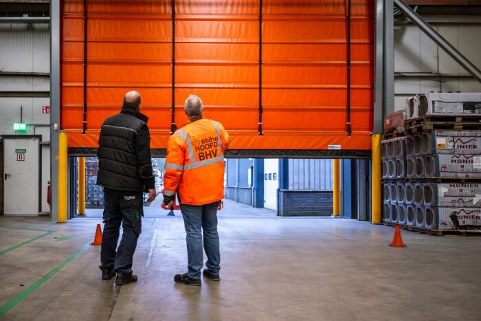 Twee medewerkers die bedrijfsdeur controleren